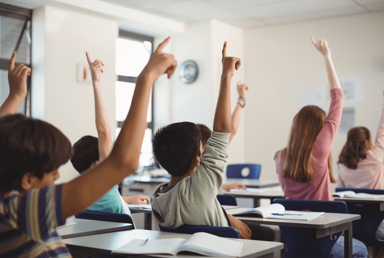 jovens levantam mão em sala de aula